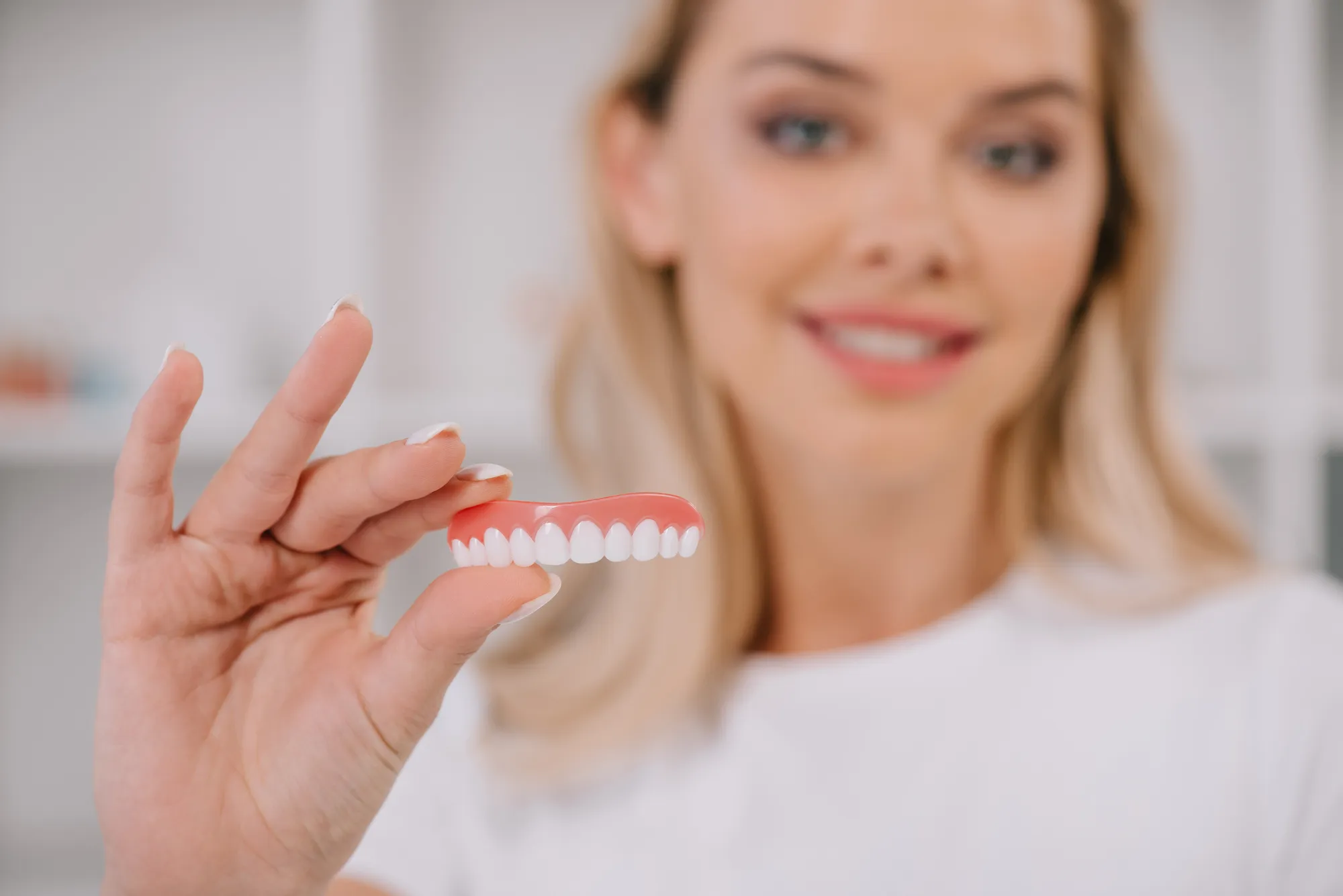 A patient showing an upper denture to a dentist.