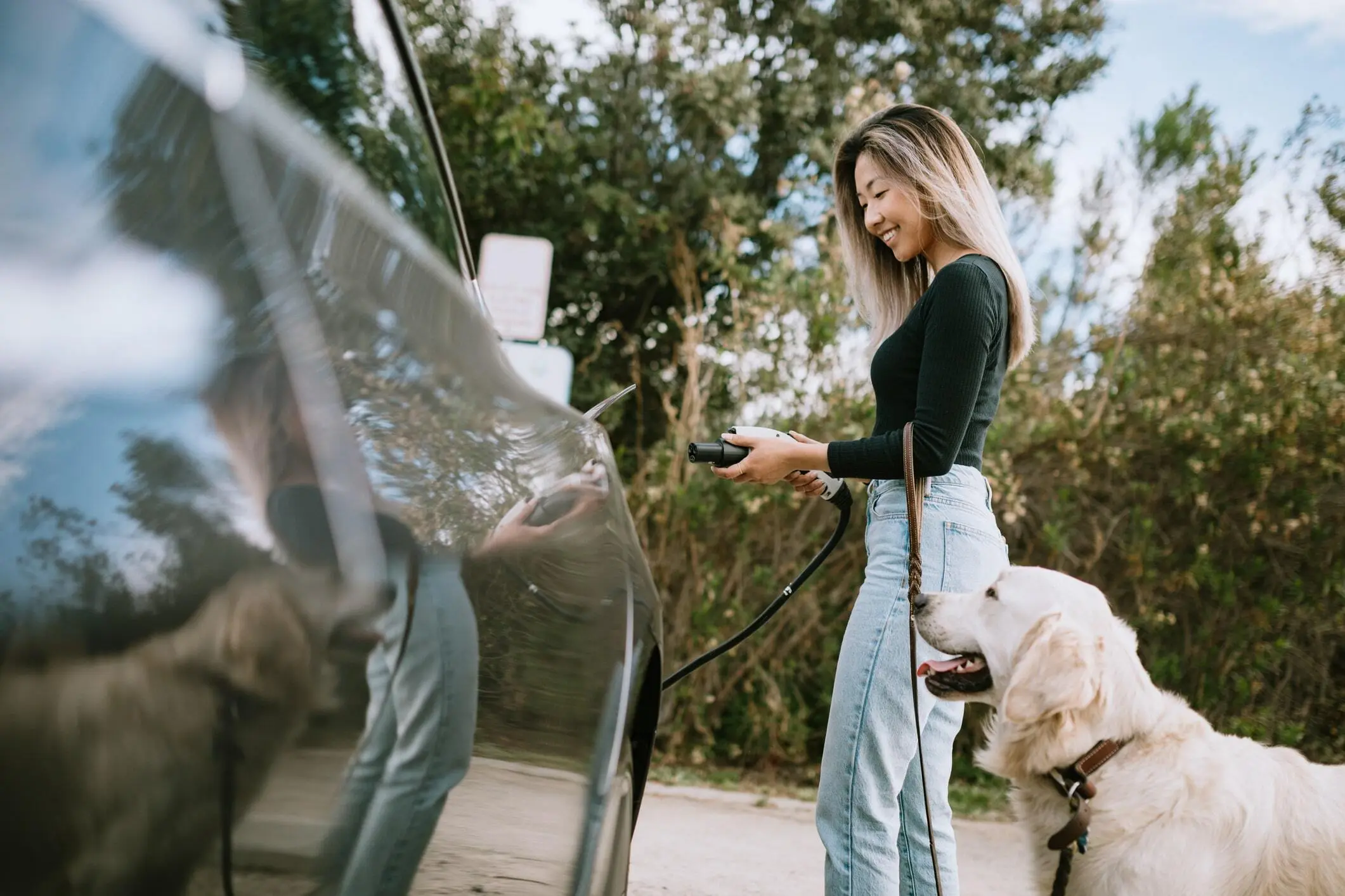 woman charging at home with dog next to her side