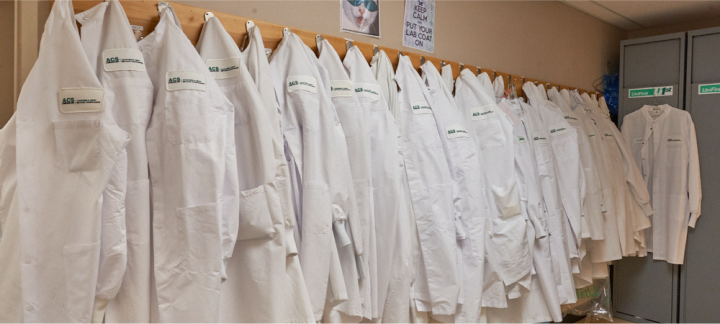 Locker room of CBD experts with collection of lab coats on a rack