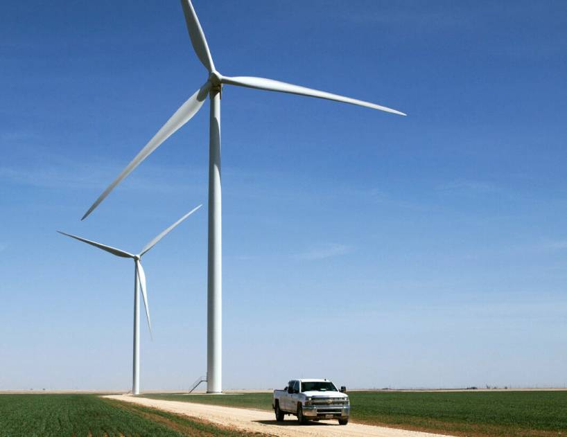 Two turbines spinning on a farmland