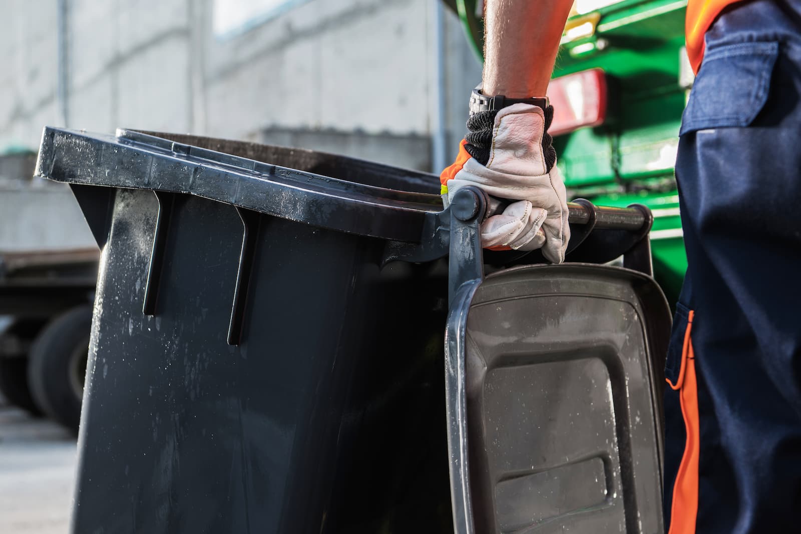 Trash can held by man in gloves