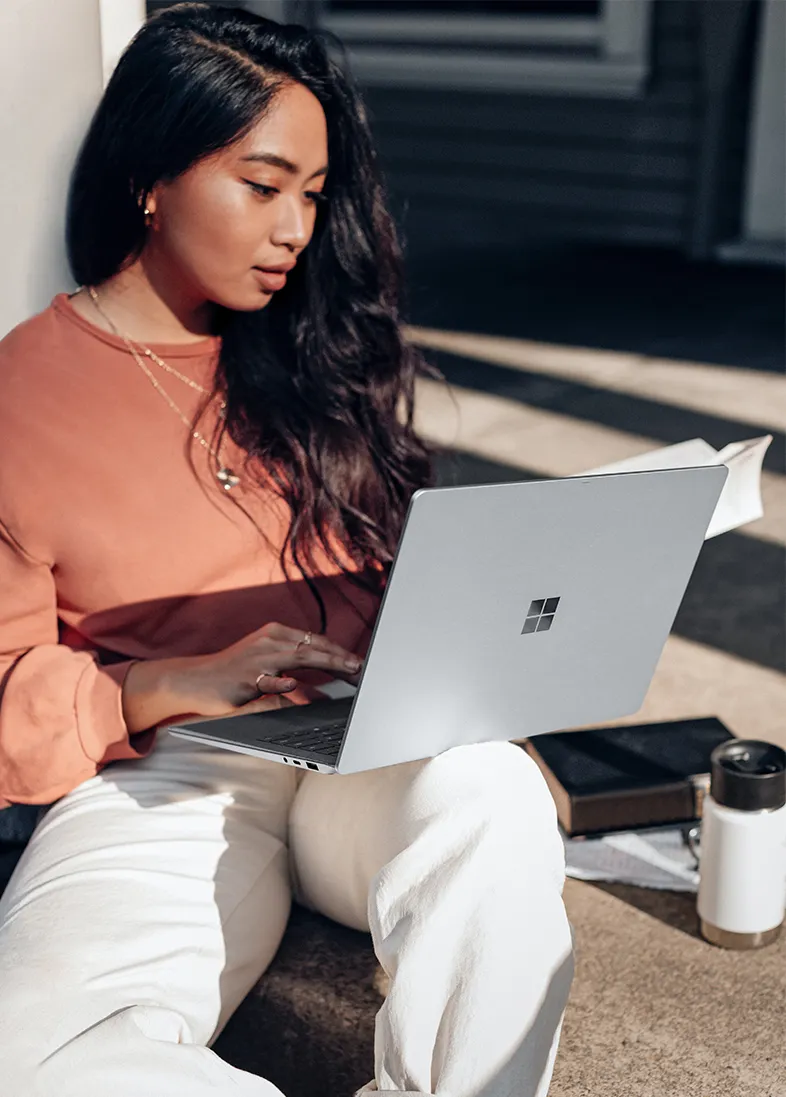 Frau auf einer Treppe mit Windows Surface Laptop.
