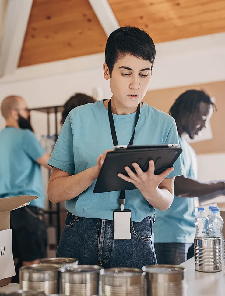 Eine ehrenamtliche Helferin hält ein iPad in den Händen