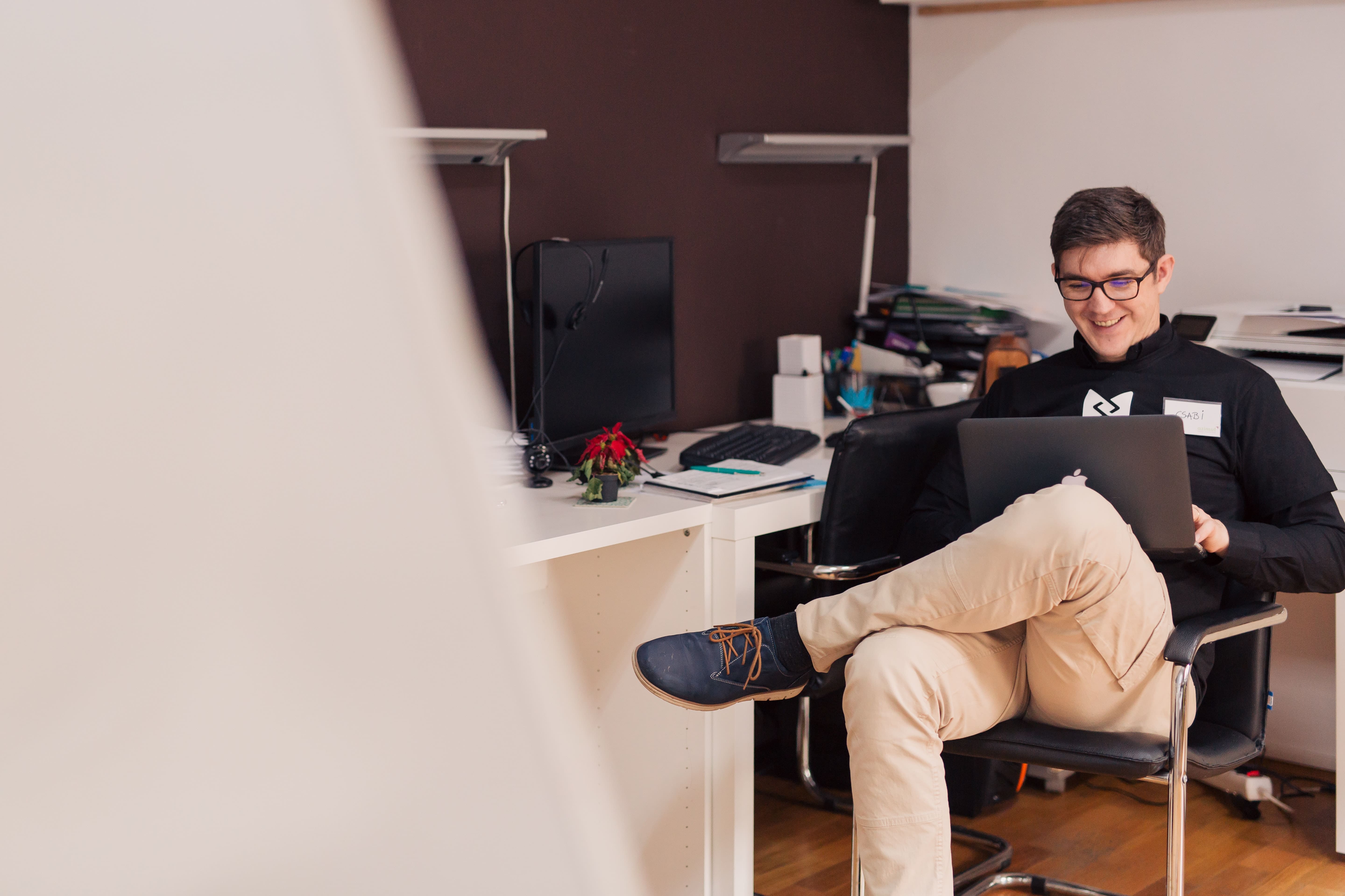 man looking at his laptop screen and laughing