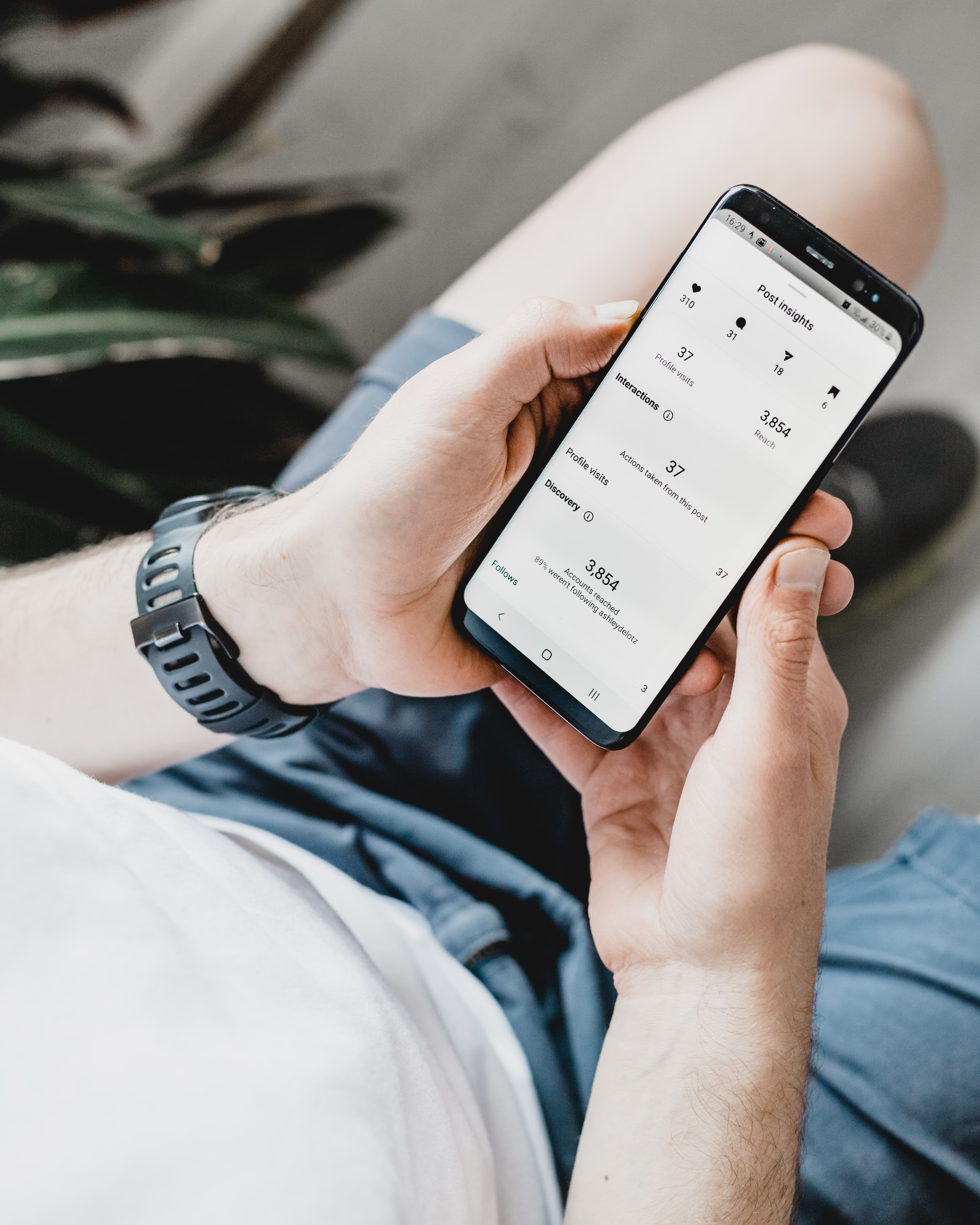 man cheking his post Insights from his phone