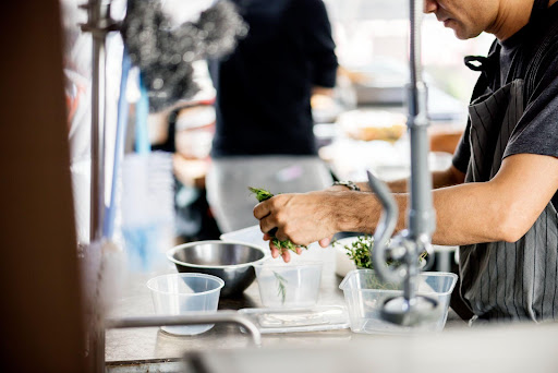 A kitchen worker preparing herbs.