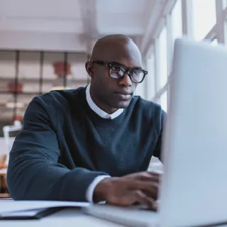 Man with glasses using his laptop