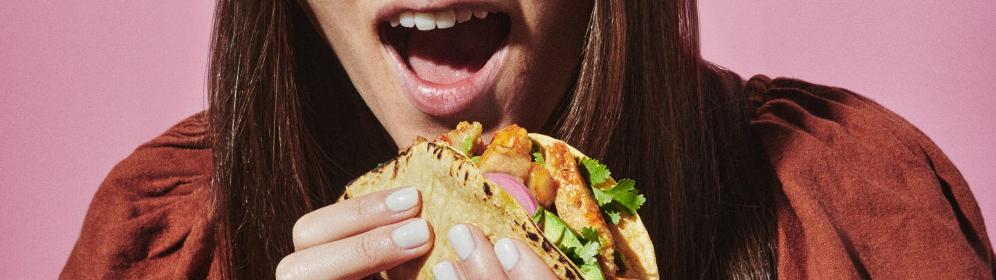 woman eating a chicken taco