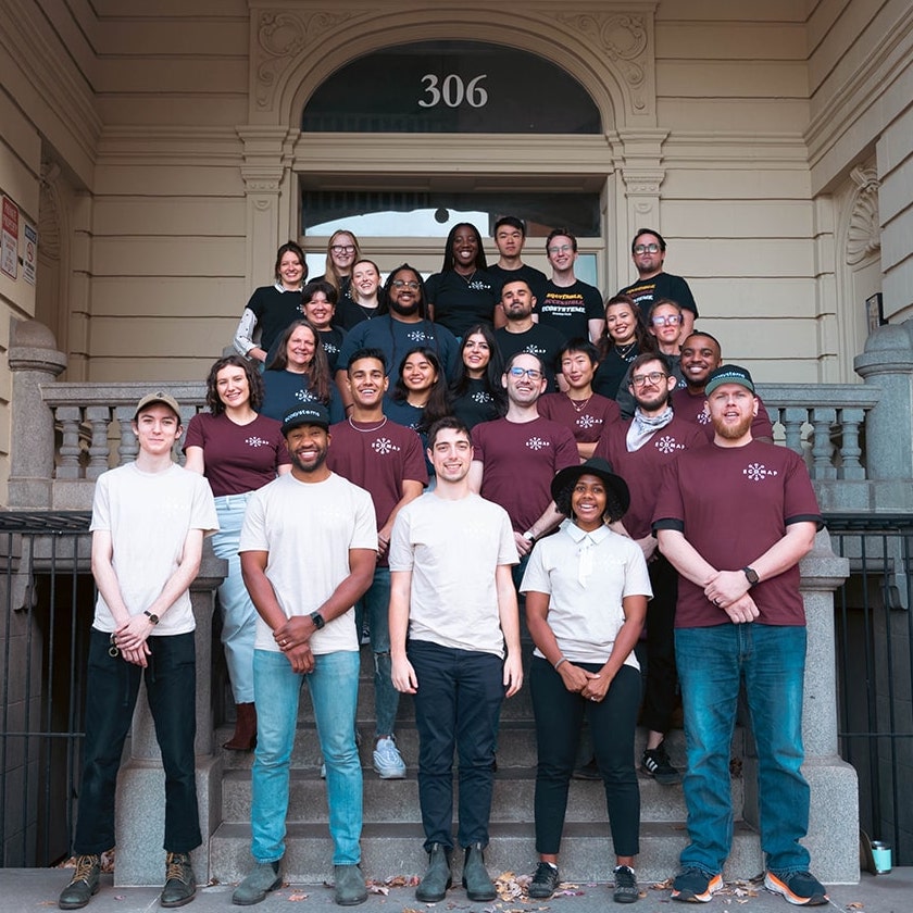 a photo of a diverse team of 30 standing on steps
