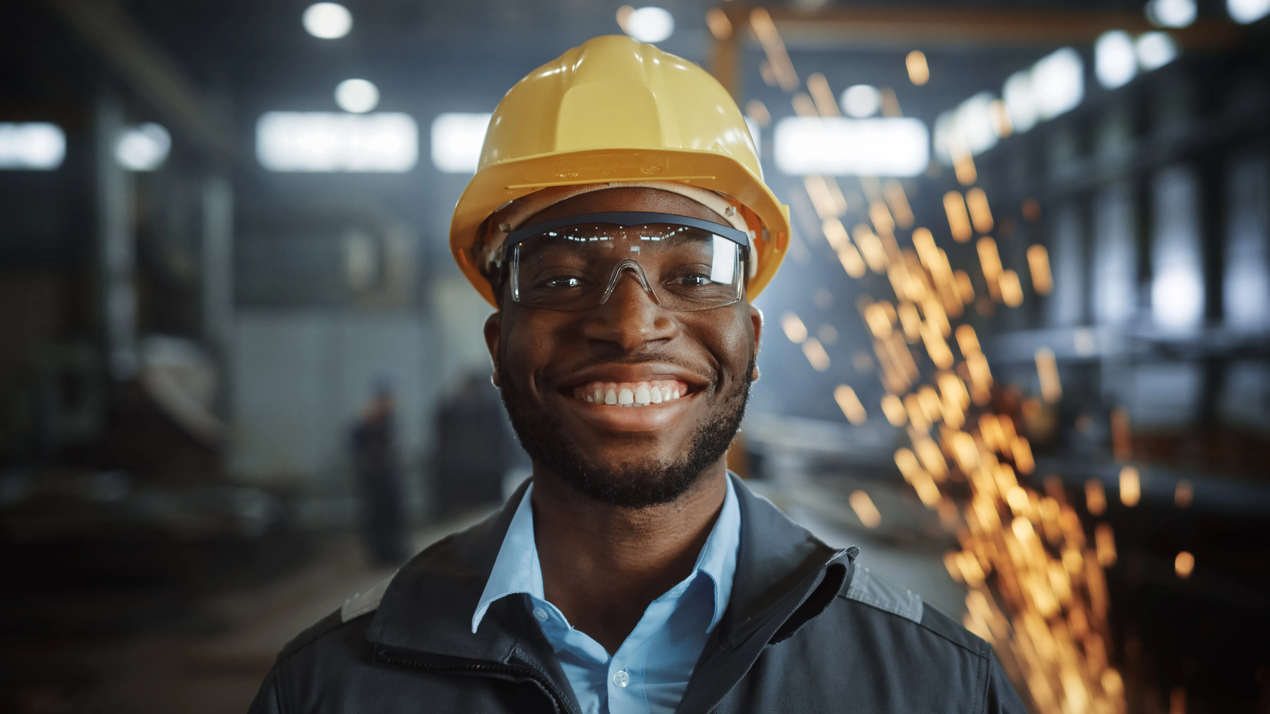 Steel worker in hard hat smiles for the camera