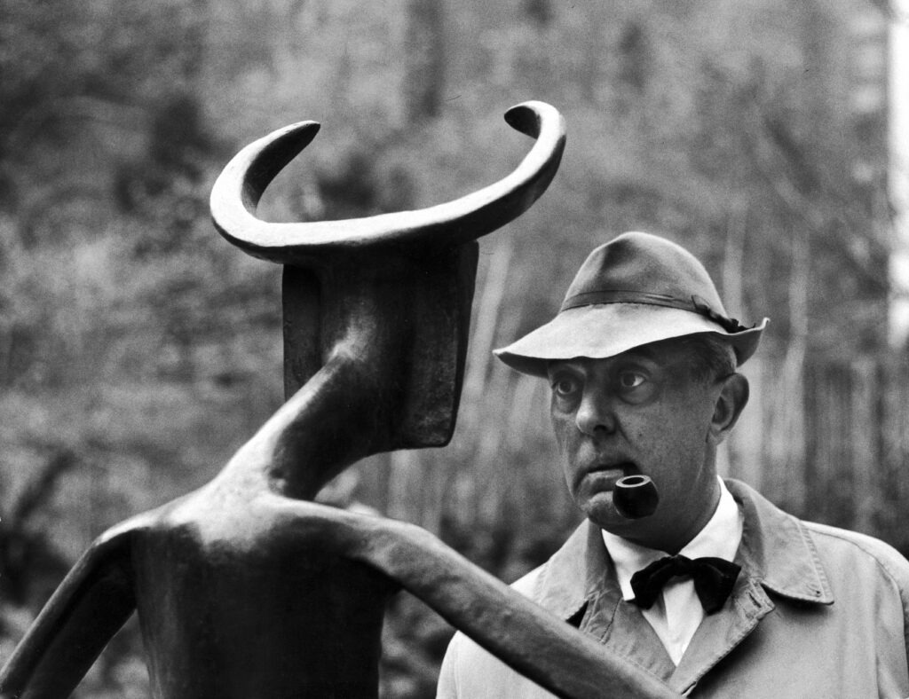 A man stares at a Max Ernst sculpture.