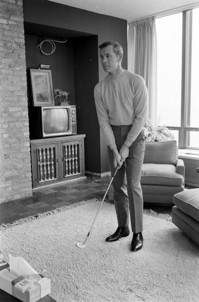 Johnny Carson playing golf in his apartment.