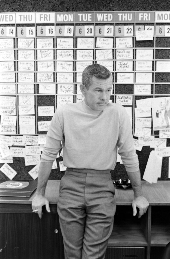 Johnny Carson leaning on a counter top.