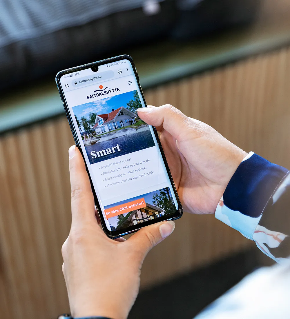 En person viser fram innholdet på en mobilskjerm