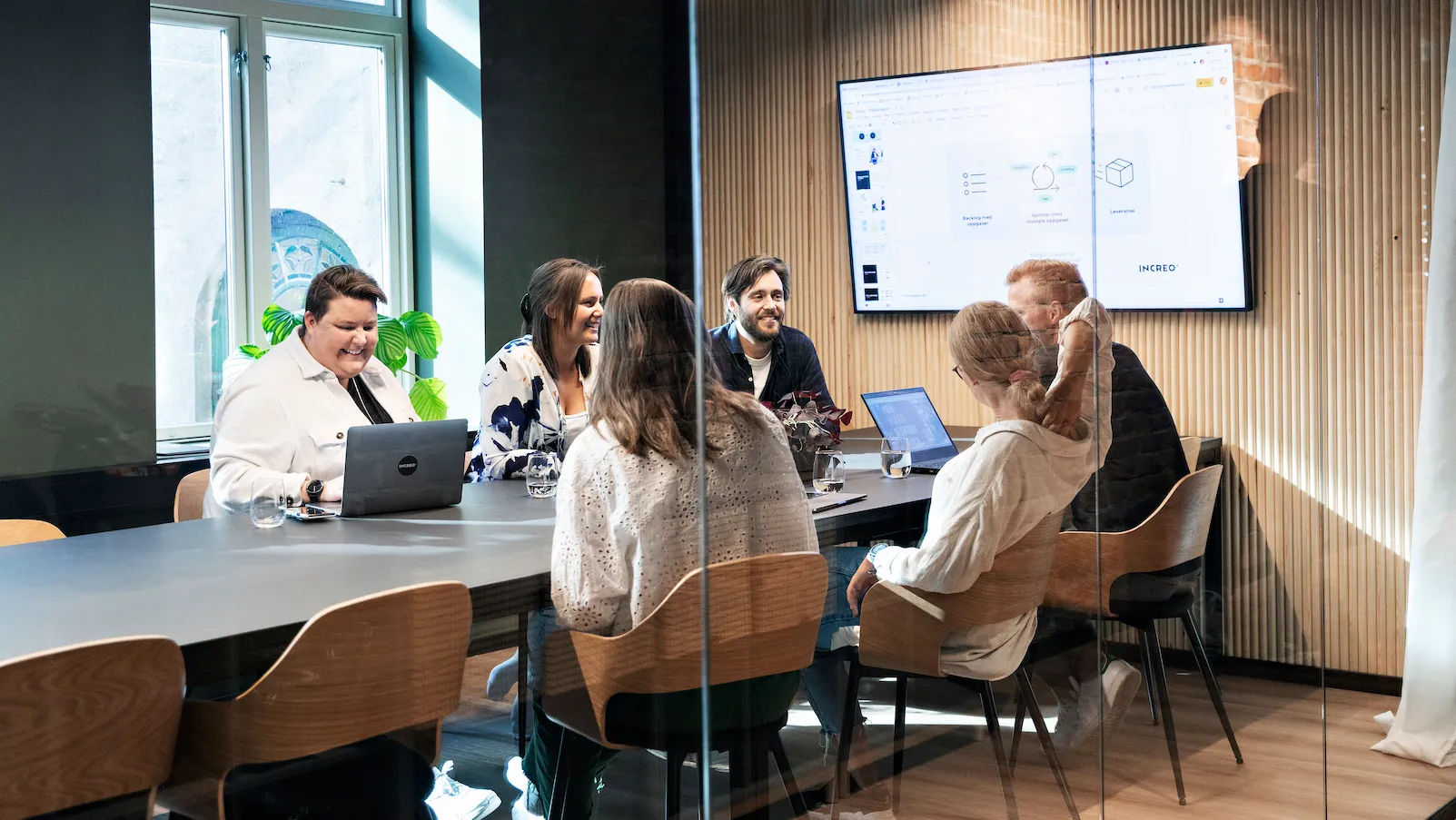 En gruppe sitter rundt et møtebord