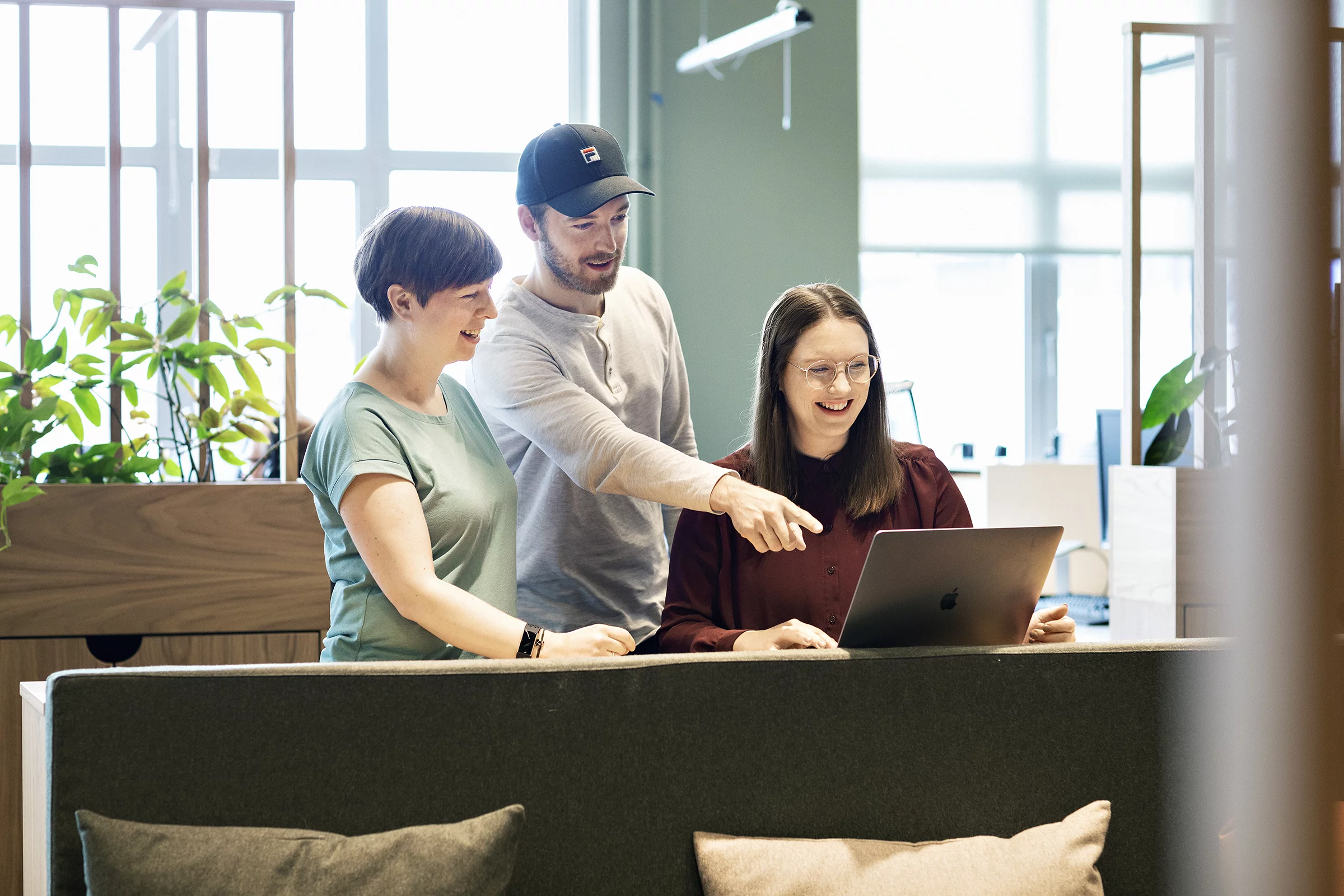 Tre personer ser på en dataskjerm. 