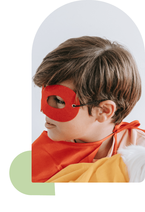 Een kleine jongen met een cape en een masker.